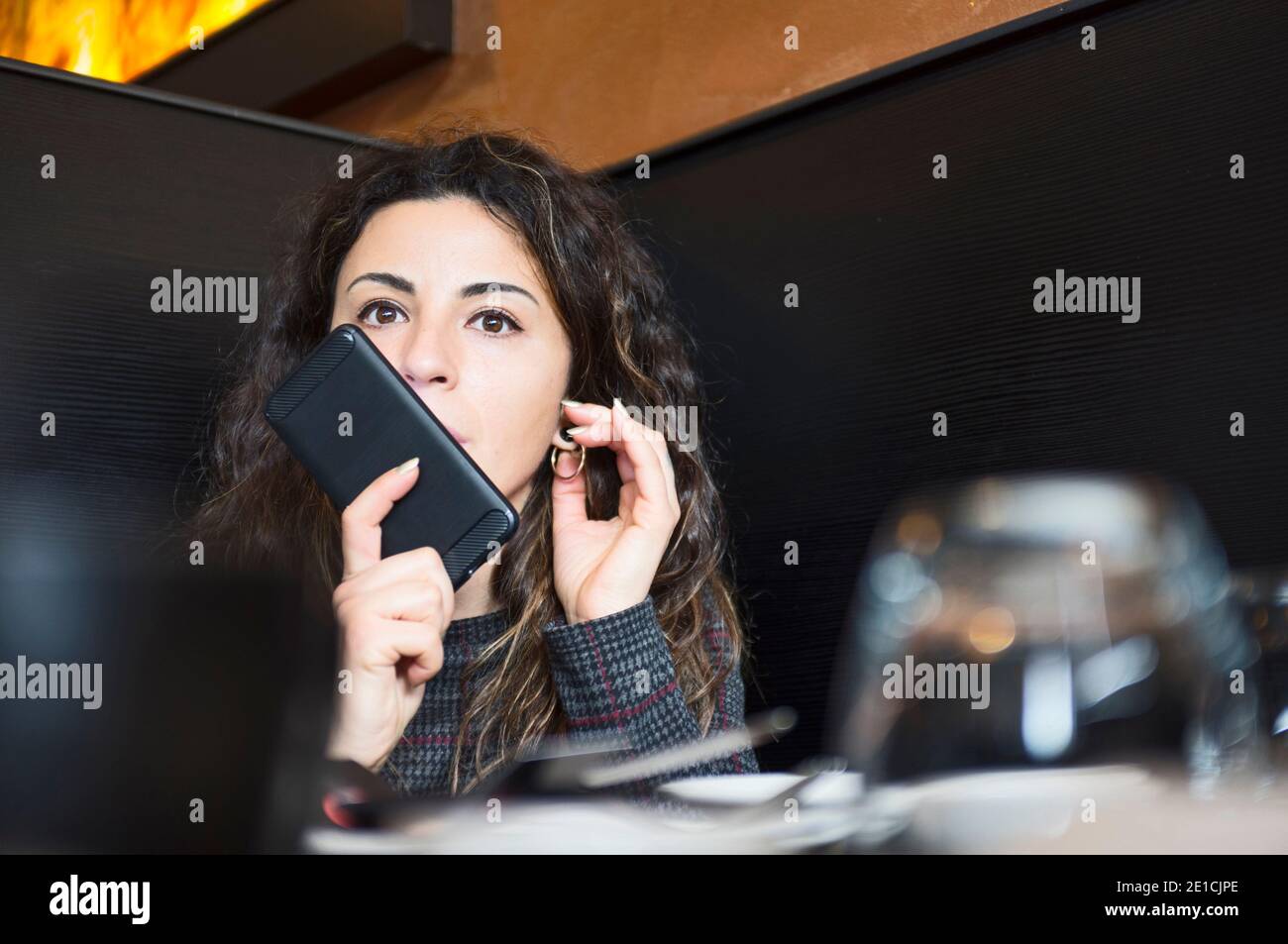 Schöne junge Geschäftsfrau sitzen und sprechen auf Handy Im Restaurant Stockfoto