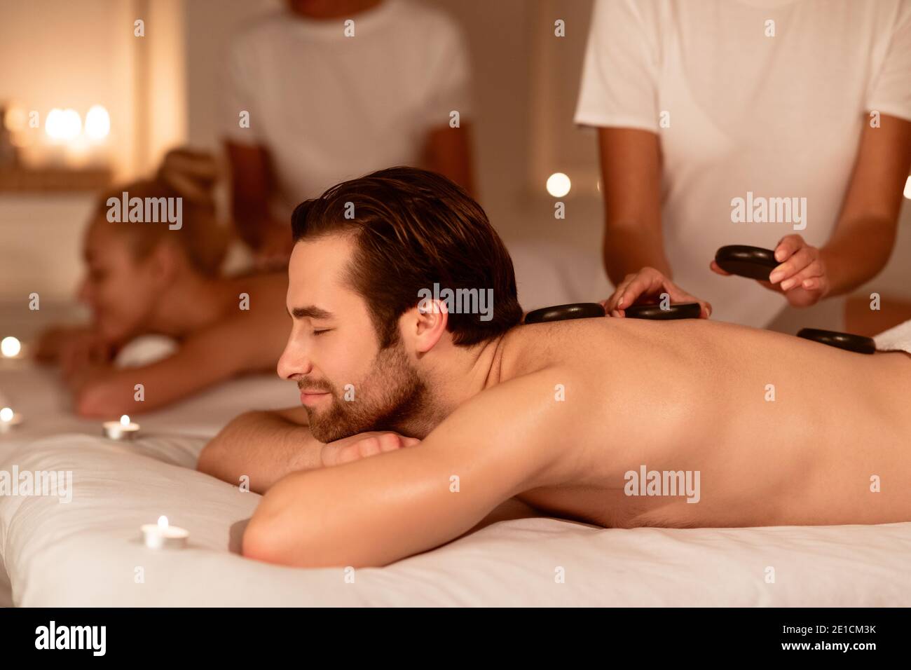 Paare Entspannen Während Einer Exotischen Massage Mit Heißen Steinen Im Spa Stockfoto