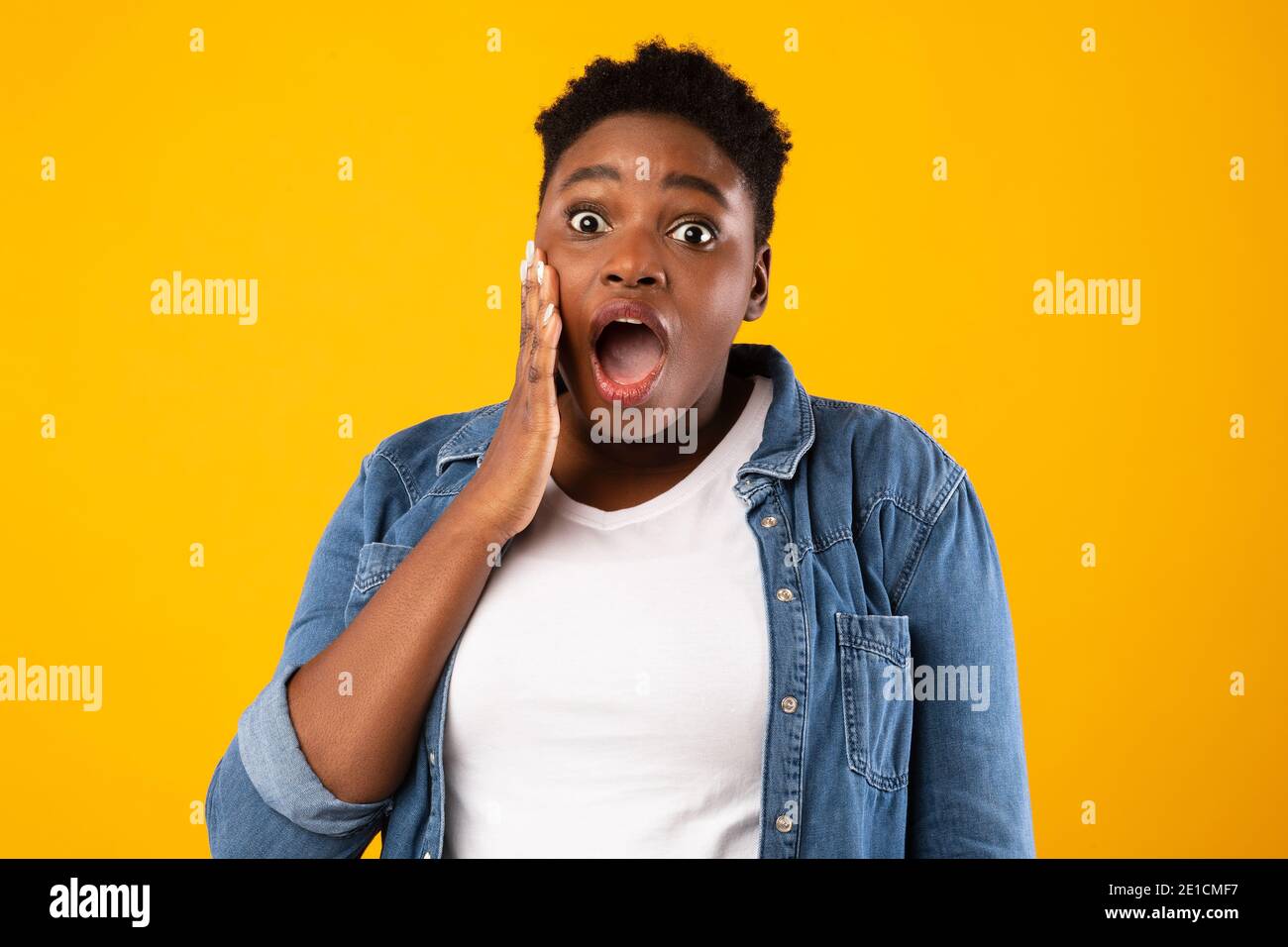 Schockiert Plus-Größe Afrikanische Frau Blick Auf Kamera Posiert, Gelber Hintergrund Stockfoto