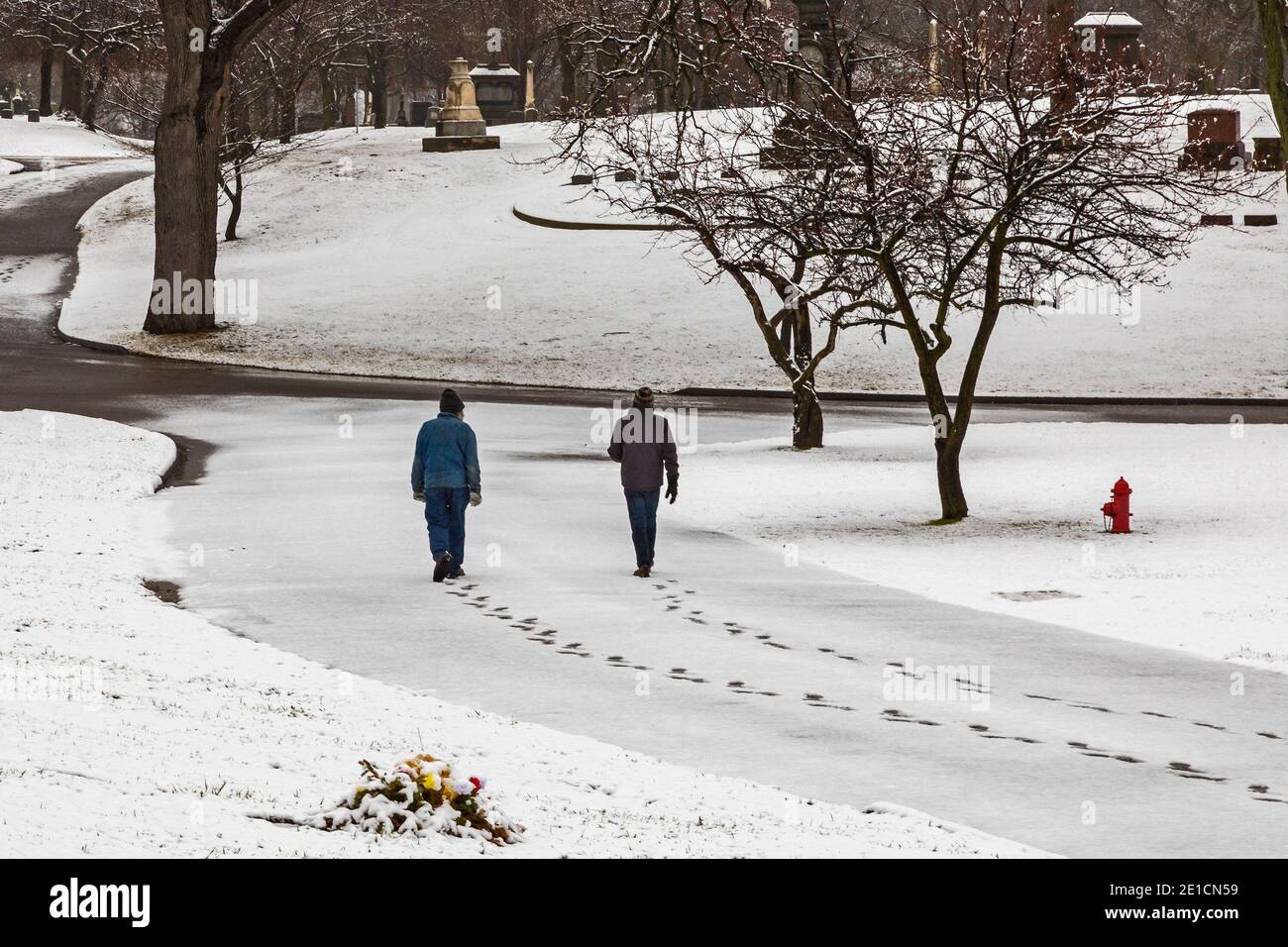 Detroit, Michigan - während der Pandemie machen zwei Menschen einen sozial distanzierten Spaziergang am frühen Morgen in Elmwood Cemetery. Stockfoto