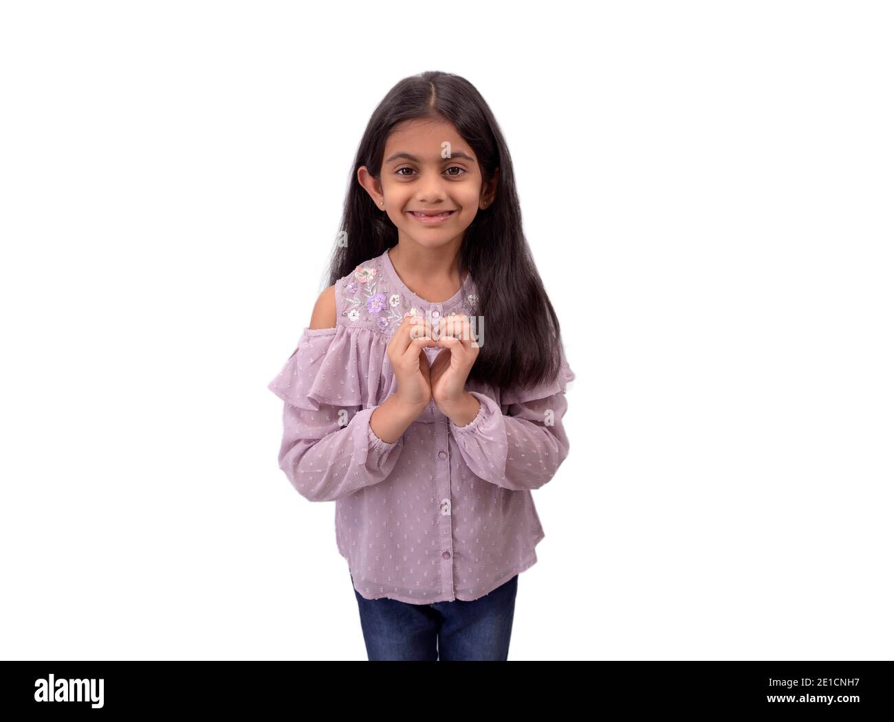 Portrait eines niedlichen kleinen indischen Mädchen mit langen Haaren zeigt Herzform Zeichen mit Händen und zum Ausdruck bringen Liebe. Stockfoto