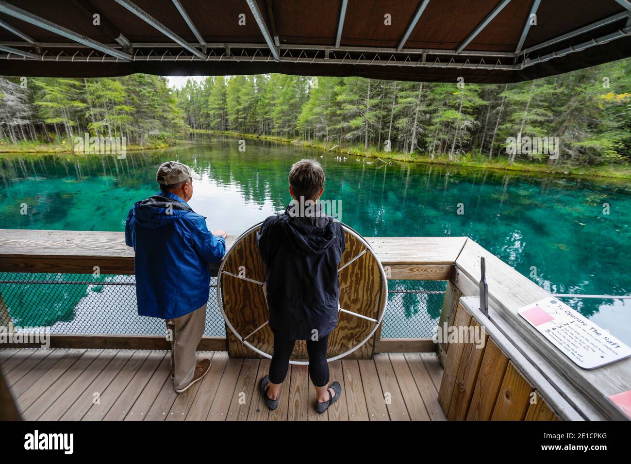 Besucher manövrieren ein Floß in Kitch-iti-kipi, Michigan's größter natürlicher Süßwasserquelle. Der Name bedeutet großes kaltes Wasser und wird manchmal auf a bezeichnet Stockfoto