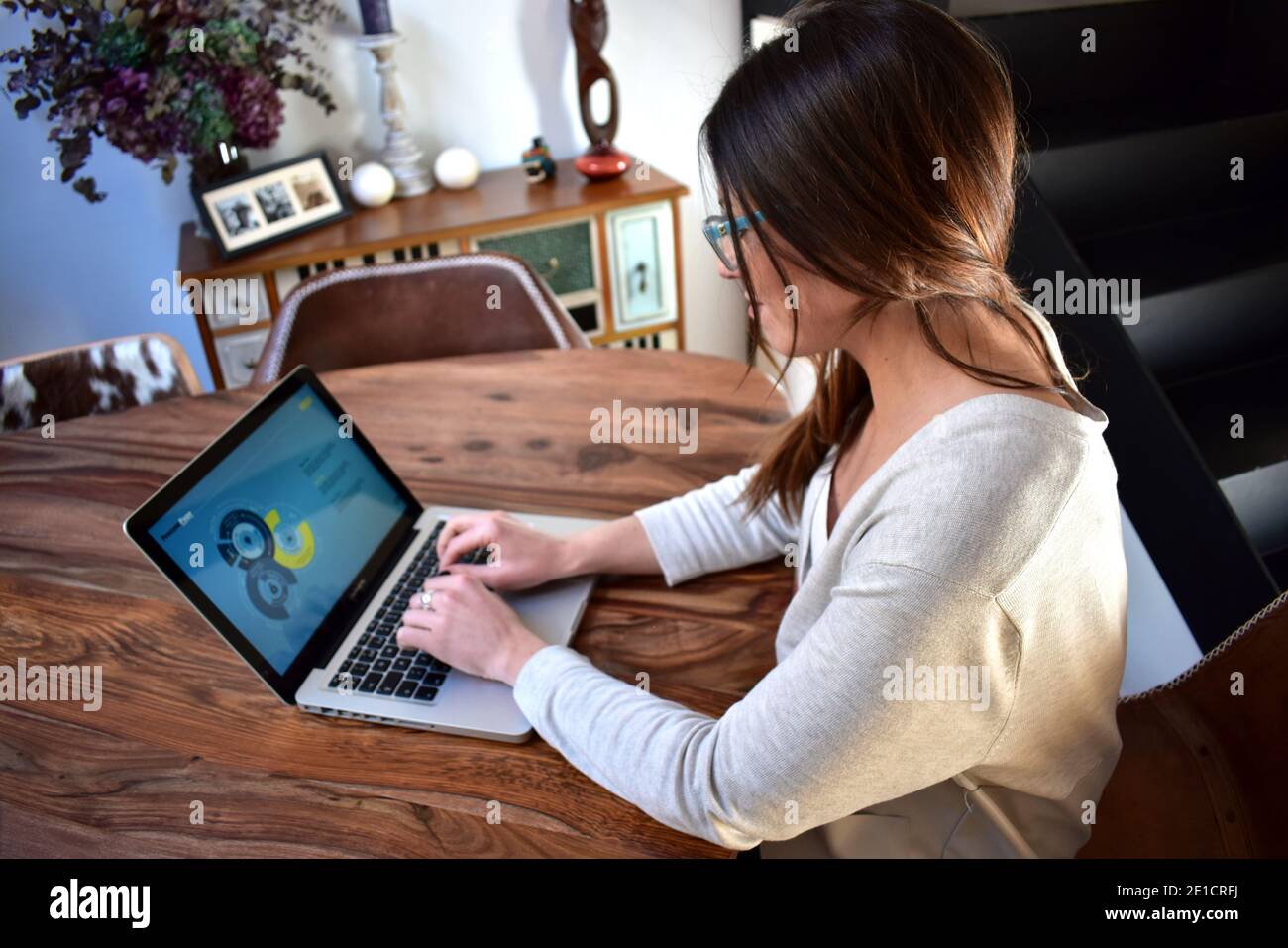 Junge Frau, die von zu Hause aus mit einem Laptop arbeitet Stockfoto