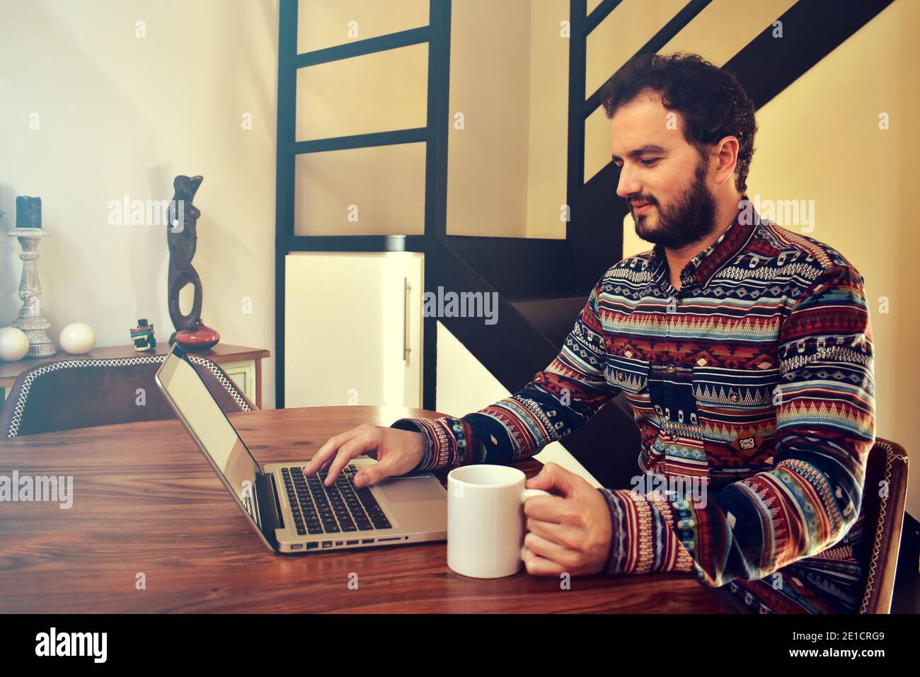 Junger Mann, der von zu Hause aus einen Kaffee getrunken hat Stockfoto