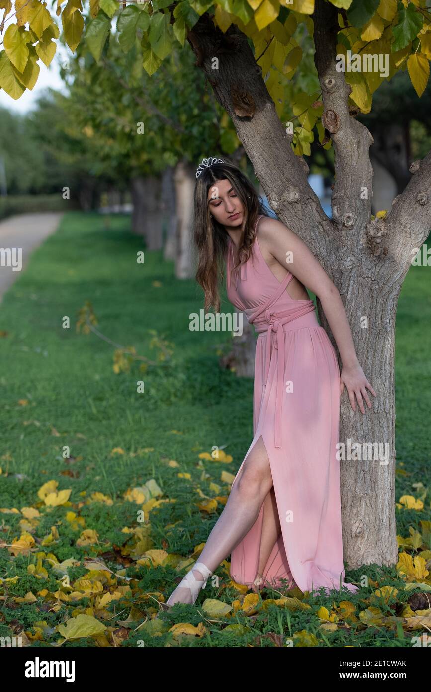 Junge Tänzerin in rosa Kleid auf Baum tanzen Ballett Im Herbst im Freien Stockfoto