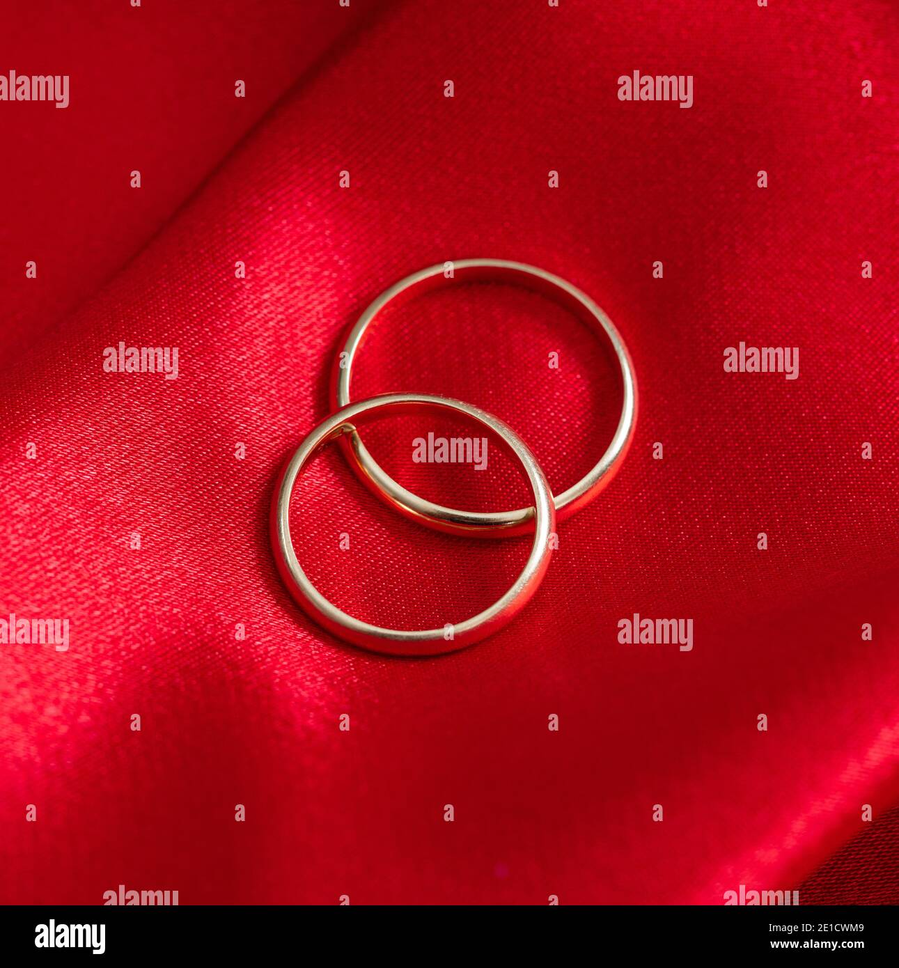 Eheringe Konzept. Draufsicht Hochzeit, Verlobungsringe auf rotem Satin Hintergrund. Schmuck für Paare in der Liebe auf Seide Tuch Leidenschaft rot colo Stockfoto