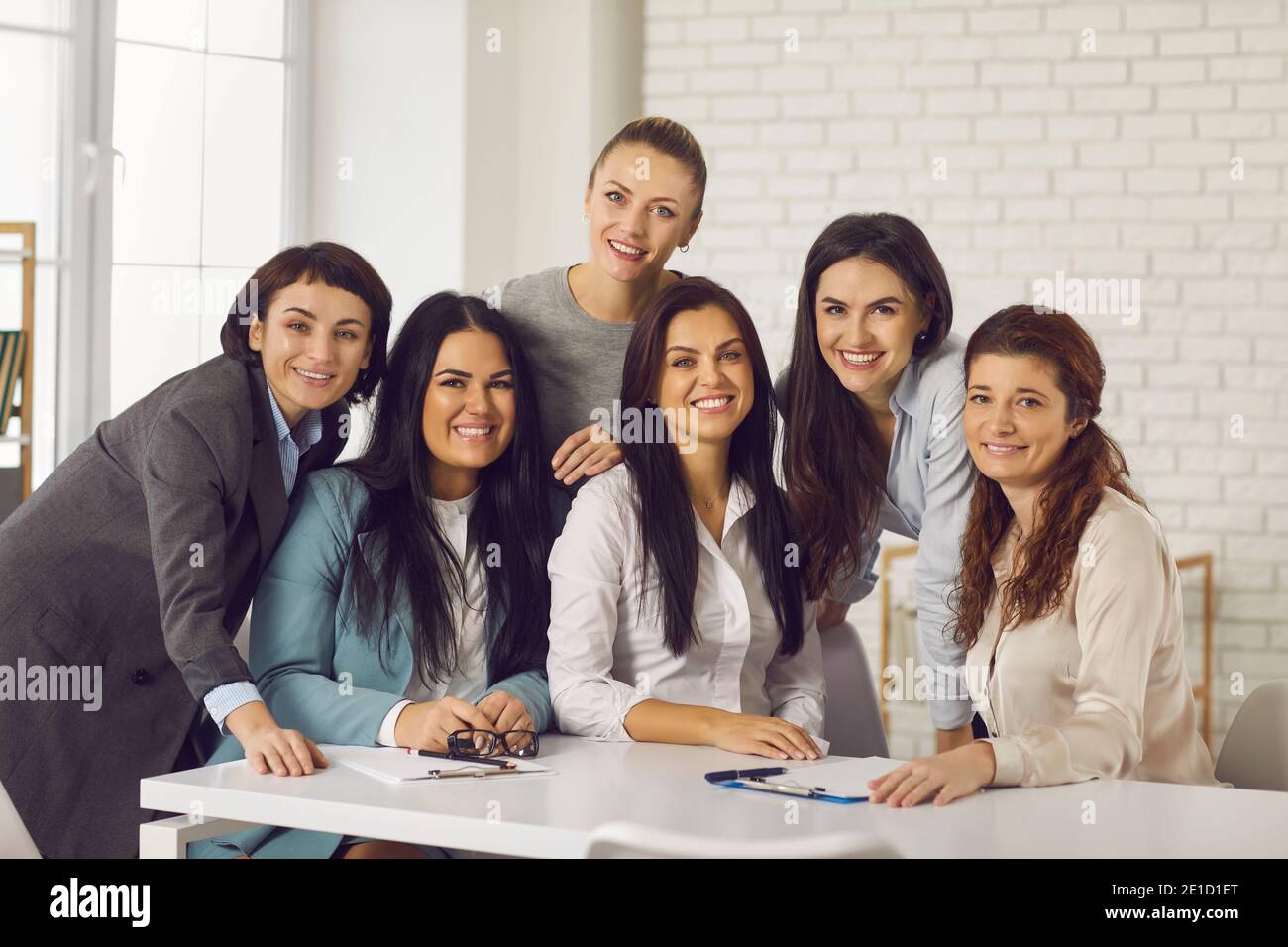 Gruppenportrait von glücklichen jungen Geschäftsfrauen, die vor der Kamera lächeln Während der Bürobesprechung Stockfoto