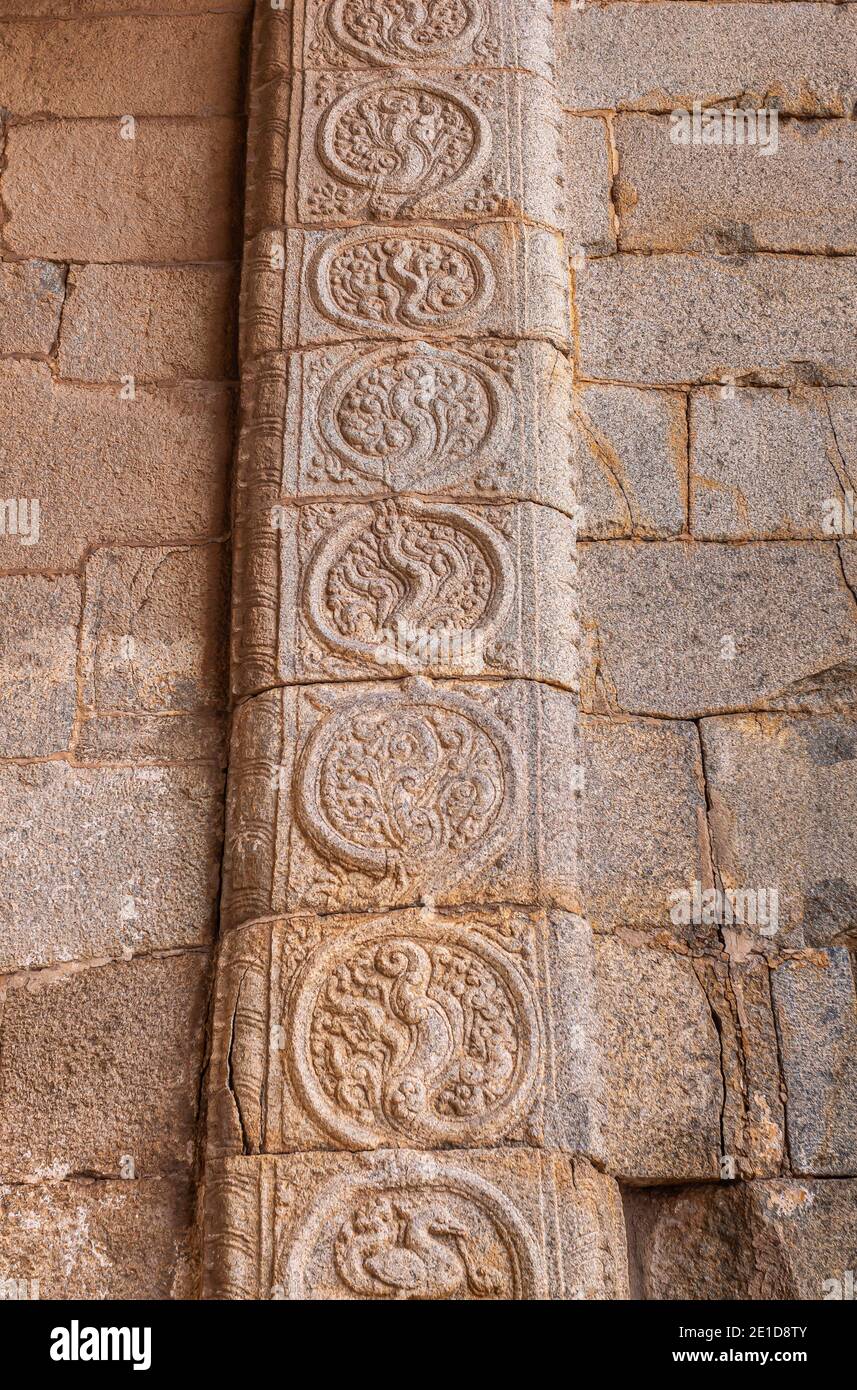 Hampi, Karnataka, Indien - 5. November 2013: Sri Krishna Tempel in Ruinen. Der aus rotem Stein gemeißelte Rahmen des massiven Eingangstors zeigt ein schlange eingekreistes Bild Stockfoto