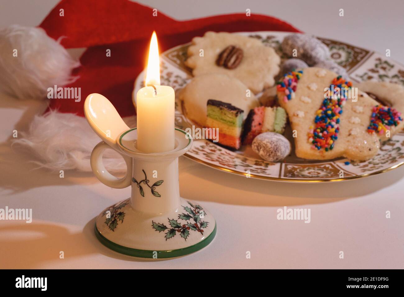 Stillleben einer brennenden Weihnachtskerze mit einem Teller frisch gebackener Plätzchen, USA Stockfoto