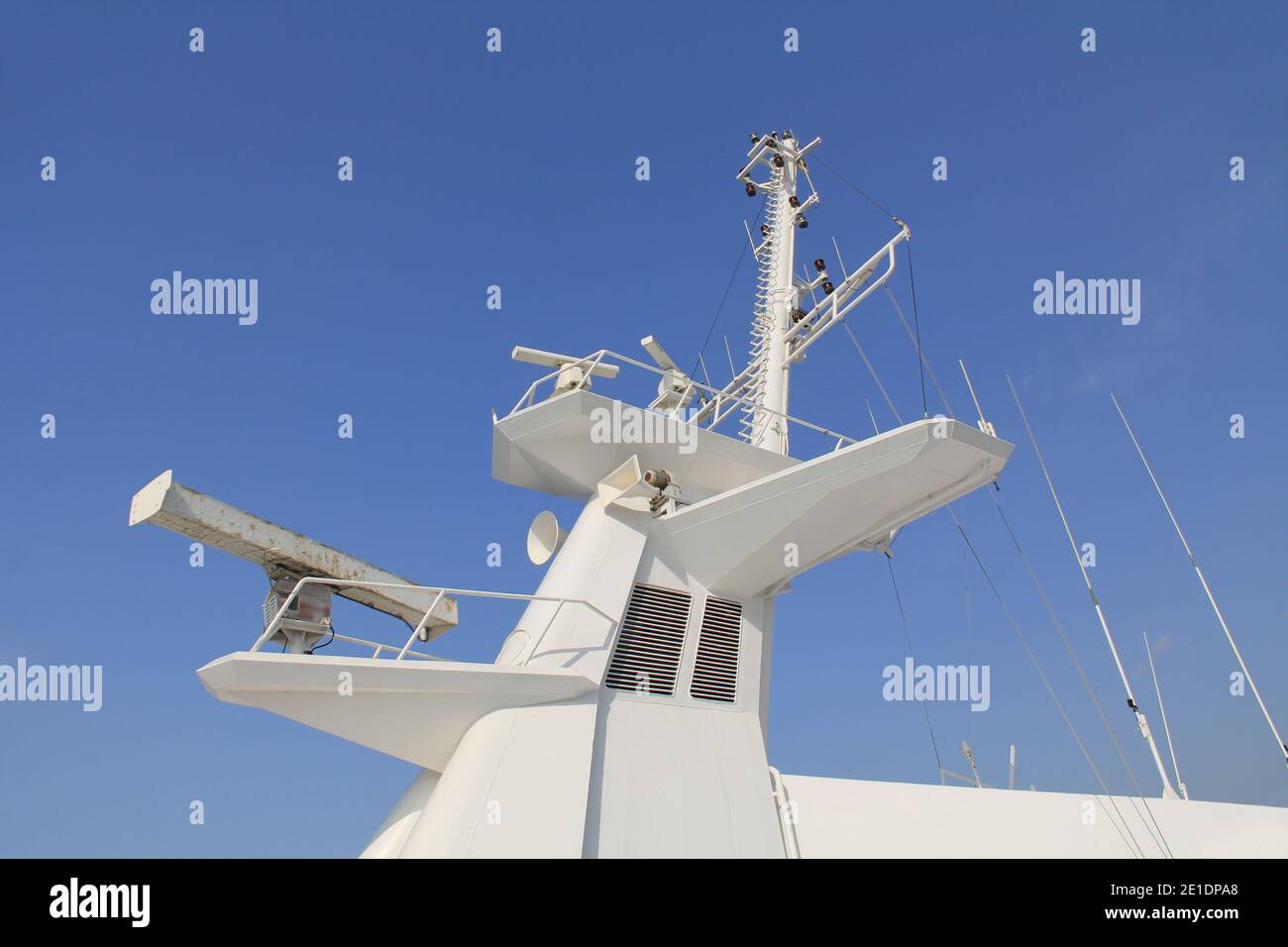 Der weiße Mast eines Kreuzfahrtschiffes mit Navigationsausrüstung, Radar, Hörnern und Blauhimmel-Kopierraum. Stockfoto