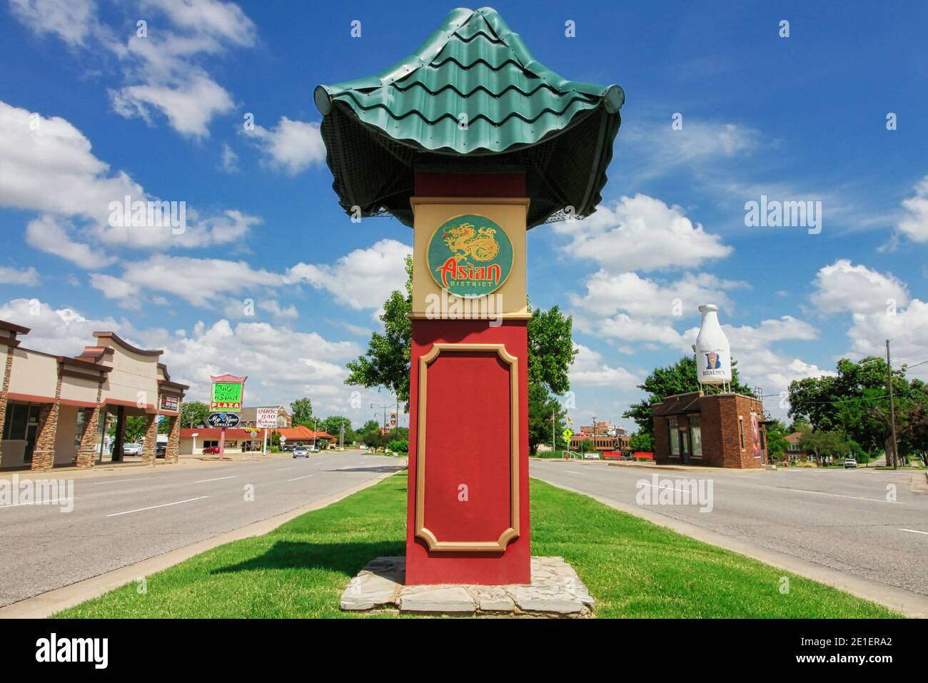 Ein Schild mit einem typisch asiatischen Dach begrüßt die Fahrer im Oklahoma City Asian District mit dem ikonischen Milchflaschengebäude im Hintergrund. Stockfoto
