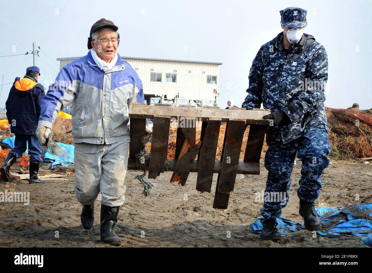 Beauftragt mit der Naval Air Facility Misawa, Japan Petty Officer 2. Klasse John Dicola, Aeriographer's Mate, aus New York, hilft bei der Beseitigung von Trümmern während einer Säuberungsaktion am Misawa Fishing Port. Etwa 92 Seeleute von NAFM haben sich freiwillig für die Hilfsmaßnahmen eingesetzt, um Mitarbeiter der Stadt Misawa und Mitglieder der örtlichen Gemeinde zu unterstützen. Foto von NVNS via ABACAPRESS.COM Stockfoto