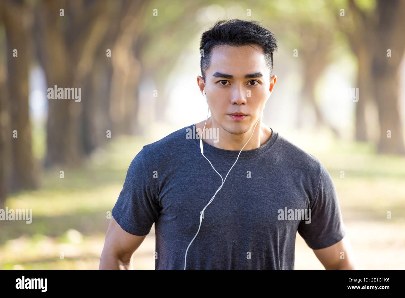 Schöner asiatischer junger Mann, der morgens im Park trainiert Stockfoto