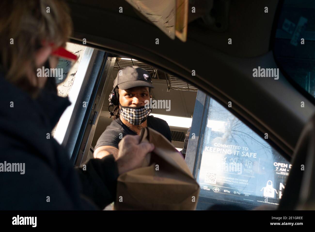 Maskierte Taco Bells Fahrt durch die Kassiererin, die während der Covid-Pandemie bestellte Lebensmittel an die Kundin in ihrem Auto übergab. St. Paul Minnesota, USA Stockfoto