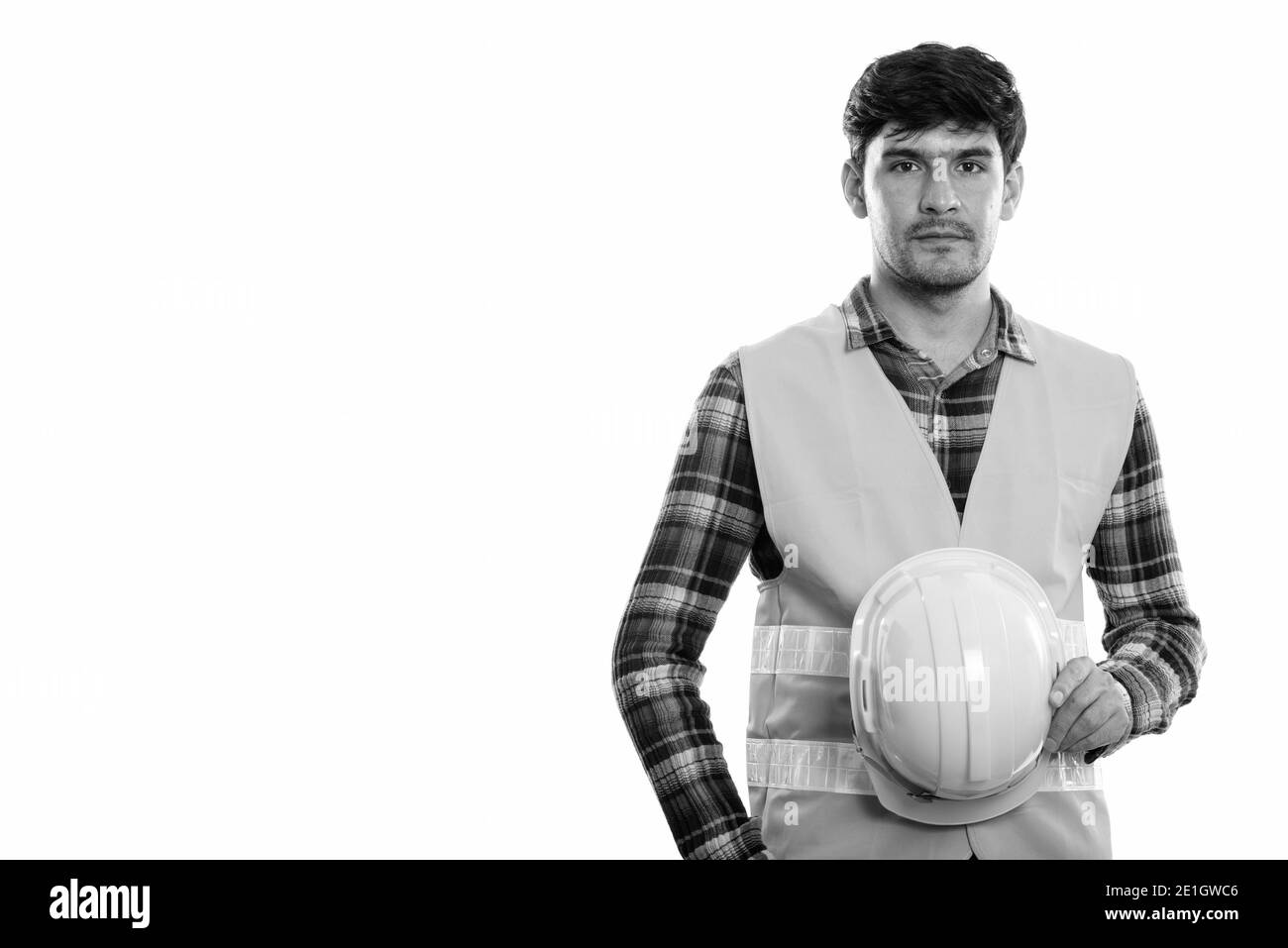 Studio shot der jungen Persischen mann Bauarbeiter holding Schutzhelm Stockfoto