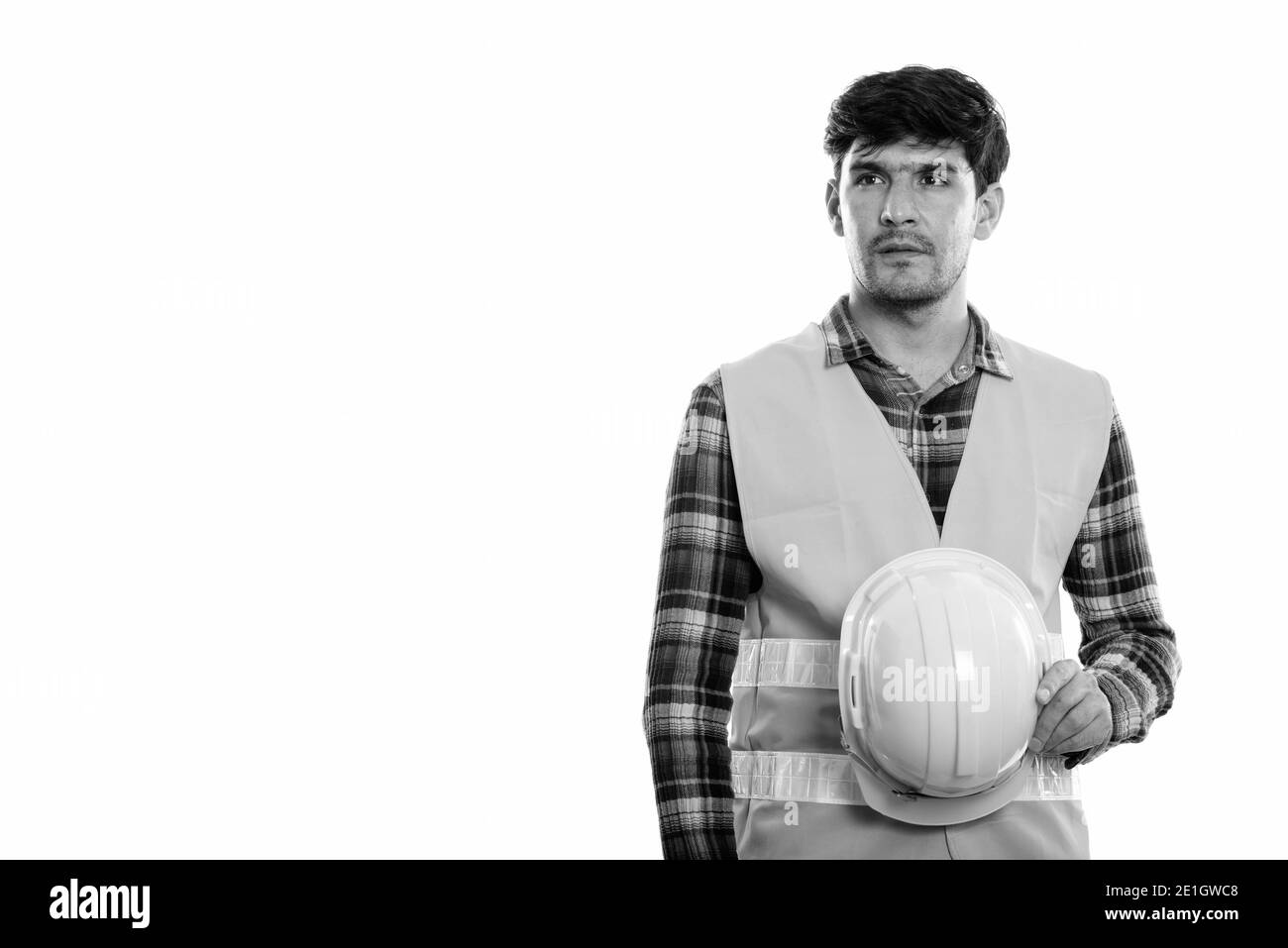 Jungen persischen Mann Bauarbeiter holding Schutzhelm beim Denken Stockfoto