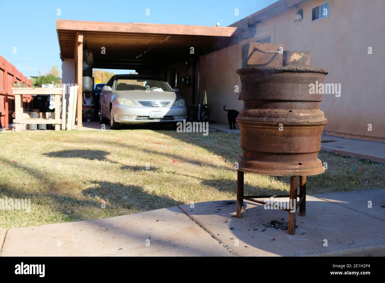 Gusseisen Holzofen und Heizung aus zwei Rädern zusammen geschweißt; außerhalb eines Hauses für die Heizung eines Hinterhofs oder Terrasse im Freien verwendet. Stockfoto