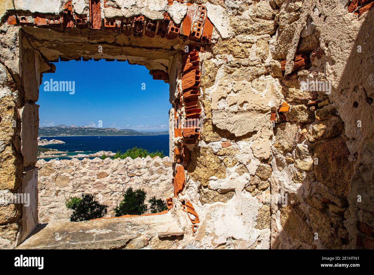 Buntes Fenster Blick auf die Insel Caprera von der Ruine Batteria Battistoni an der Küste Nordsardiniens in Baia Sardinia. Stockfoto