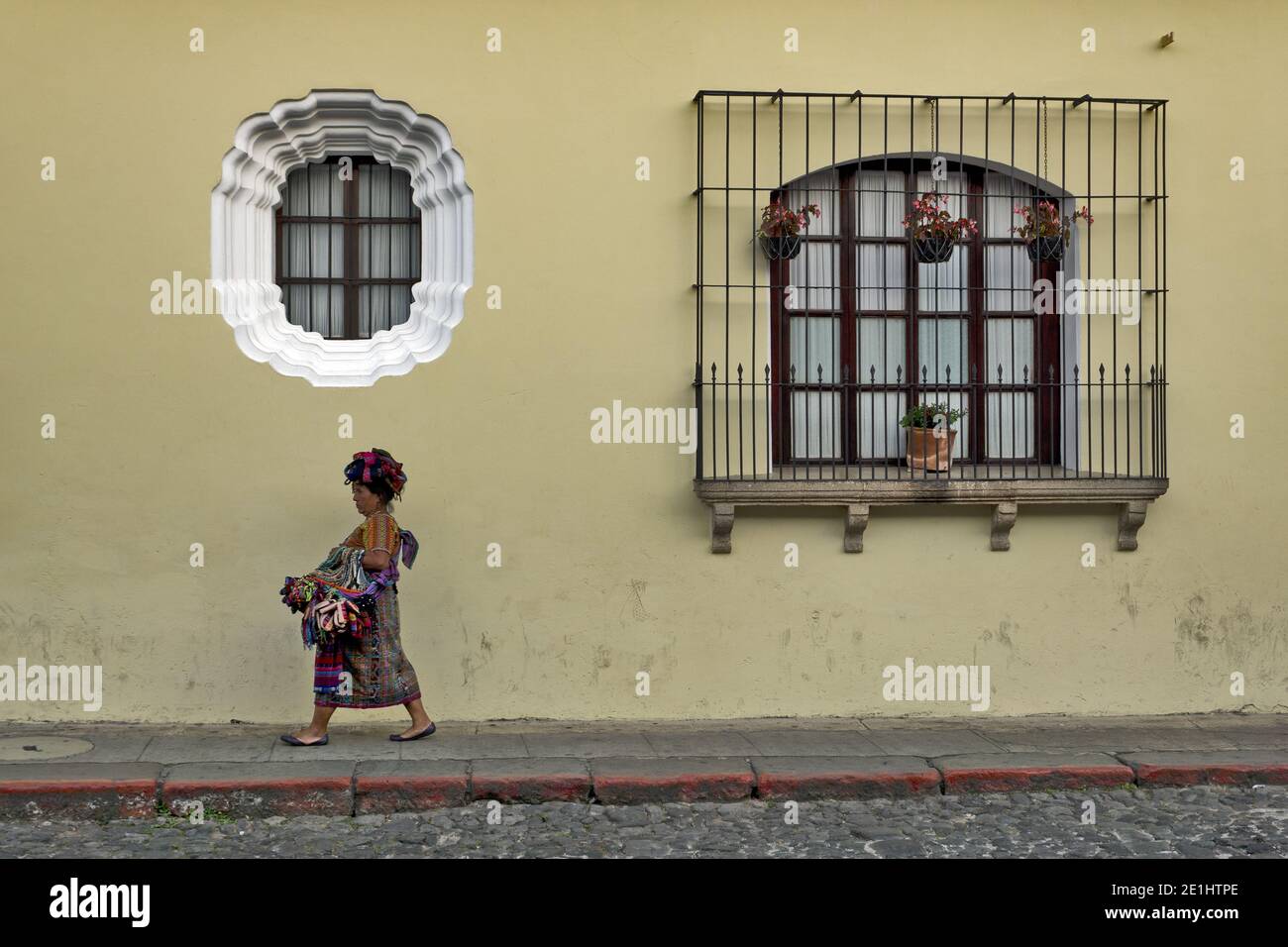 Maya-Frau in traditioneller Kleidung an einer historischen Fassade in Antigua, Guatemala, Mittelamerika Stockfoto