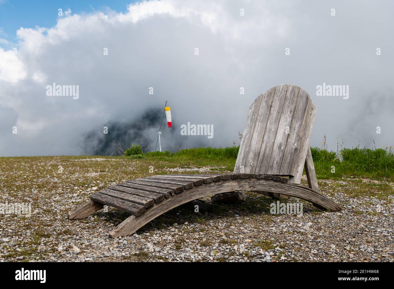 Ein rustikaler Sessel aus Holz auf einem Hügel, wolkiger Tag im Frühjahr in den österreichischen Alpen Stockfoto