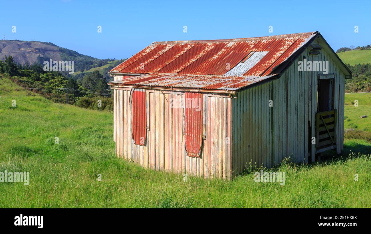 Eine alte, rustikale Holz- und Wellblech-Scheune auf einem Bauernhof in Neuseeland Hügelland Stockfoto