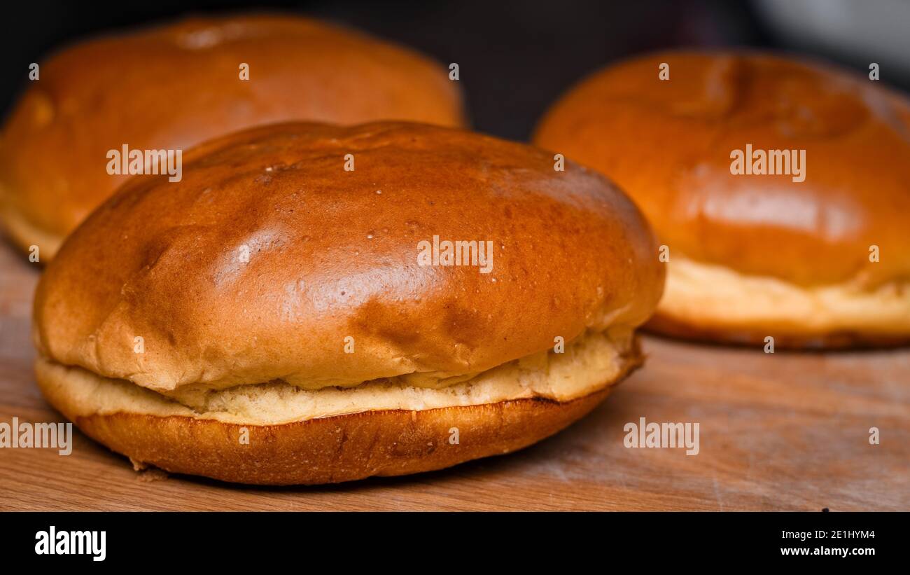 Frisch gebutterte Brioche-Brötchen auf einem Schneidebrett Stockfoto