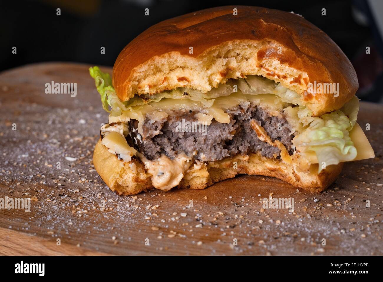 Hausgemachter Gourmet-Cheeseburger mit Happen aus Romaine-Salat, reifem Cheddar-Käse und Hummus Stockfoto