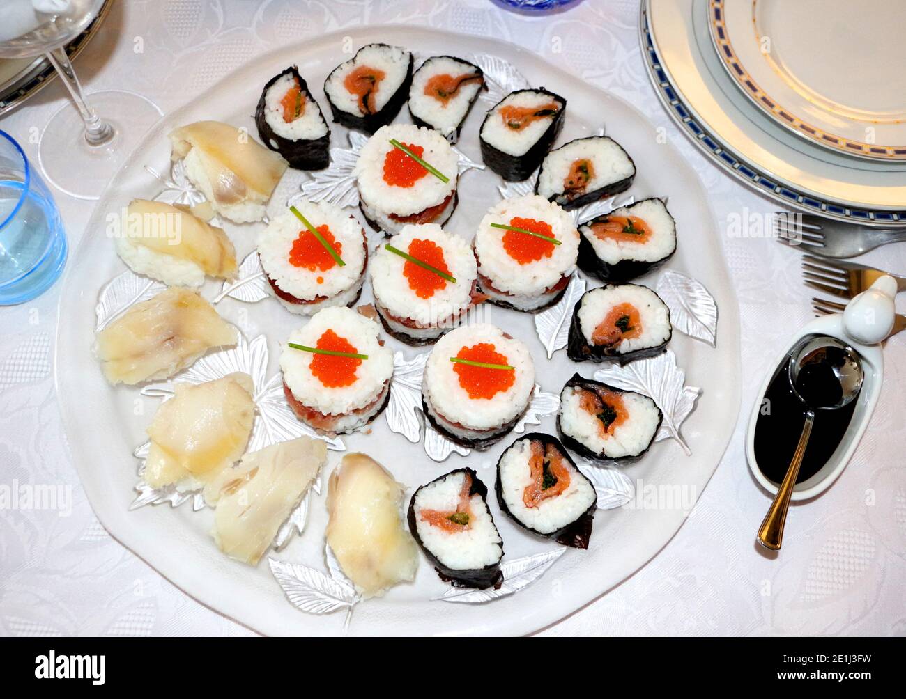 Glasplatte mit frischem, hausgemachten Sushi bereit zu sein Gegessen mit Sojasauce in einer weißen Entenschale Stockfoto