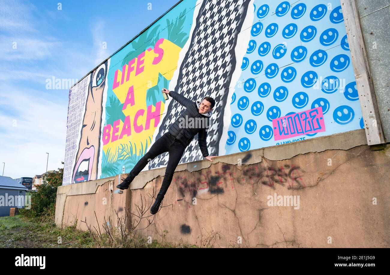 Lancing West Sussex UK 7. Januar 2021 - der Street-Künstler Luke Henley, bekannt als Wooze, hat kürzlich sein neuestes Stück "Life's A Beach" an der Lancing Seafront in der Nähe von Worthing in West Sussex mit dem letzten Schliff ausgestattet. Der Künstler erhielt die Erlaubnis, das Kunstwerk auf einer Wand hinter einer lokalen Garage mit Blick auf Lancing Green zu schaffen und er hofft, dass es die Gegend für Wanderer und Besucher erhellt : Credit Simon Dack / Alamy Live News Stockfoto