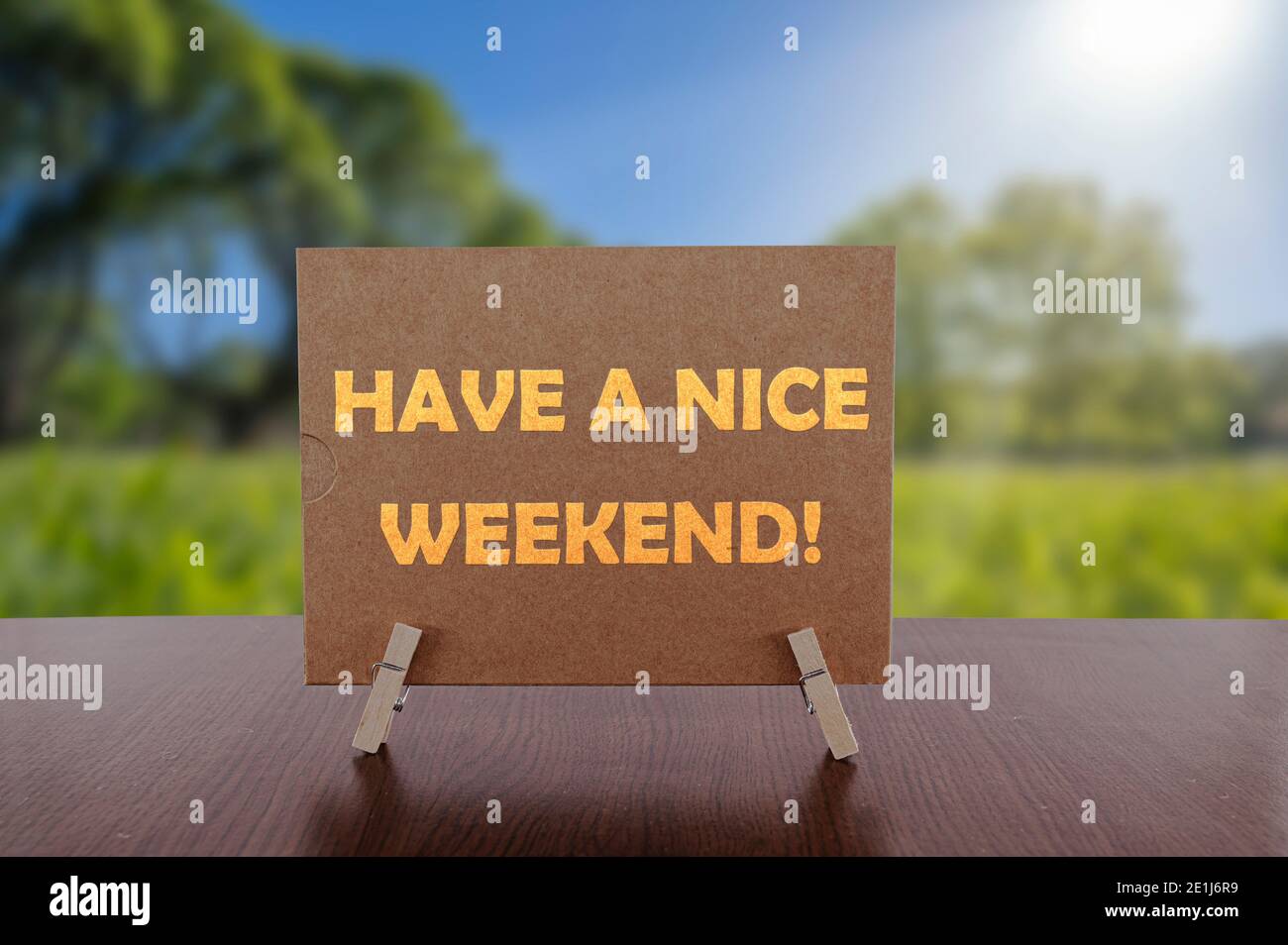 Haben Sie ein schönes Wochenende Text auf Karte auf dem Tisch mit sonnigen grünen Park Hintergrund. Stockfoto