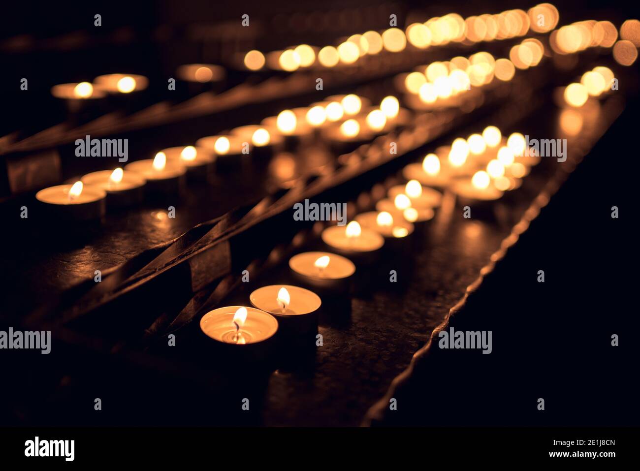 Viele kleine Teelicht-Kerzen leuchten in der Kirche Stockfoto