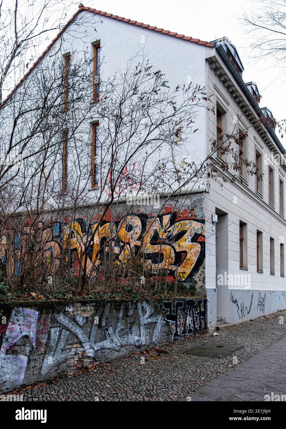 Zweigeschossiges Mehrfamilienhaus, zweigeschossiges Wohngebäude mit Graffiti-bedeckter Wand in Scheringstrasse, Mitte, Berlin, Deutschland. Stockfoto