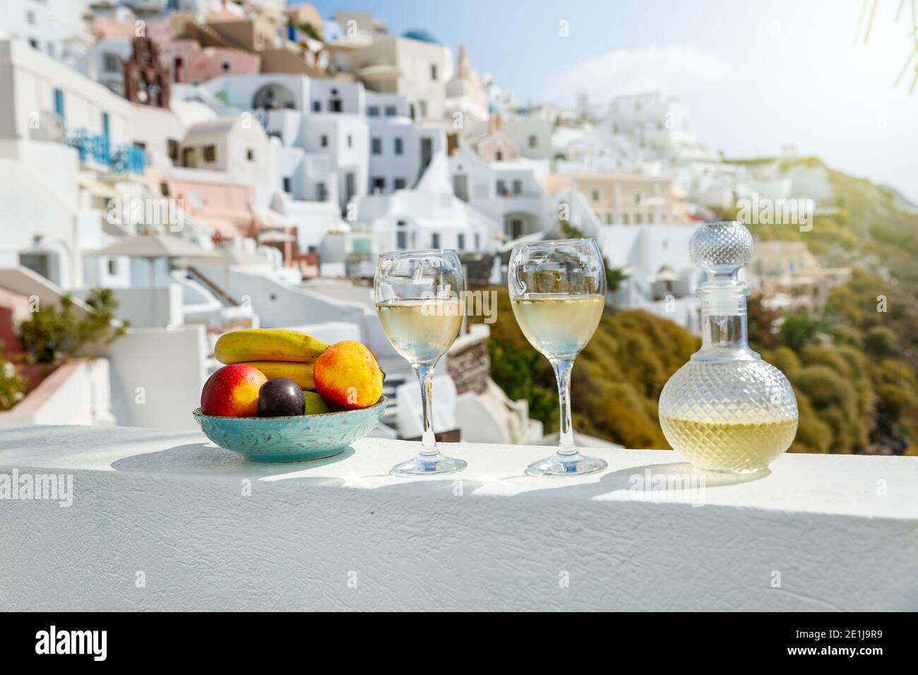 Wein und Obst für zwei vor der Kulisse der Architektur der Insel Santorini Stockfoto