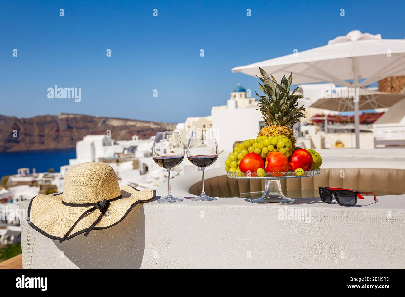 Wein und Obst für zwei Personen auf dem Hintergrund des Meer und die Insel Santorini Stockfoto