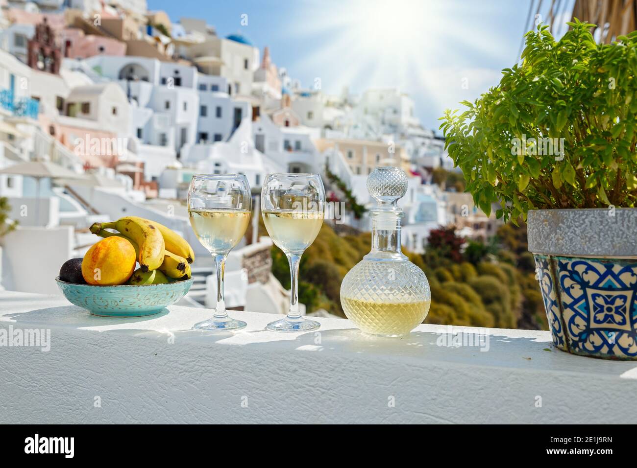 Wein und Obst für zwei vor der Kulisse der Architektur der Insel Santorini Stockfoto