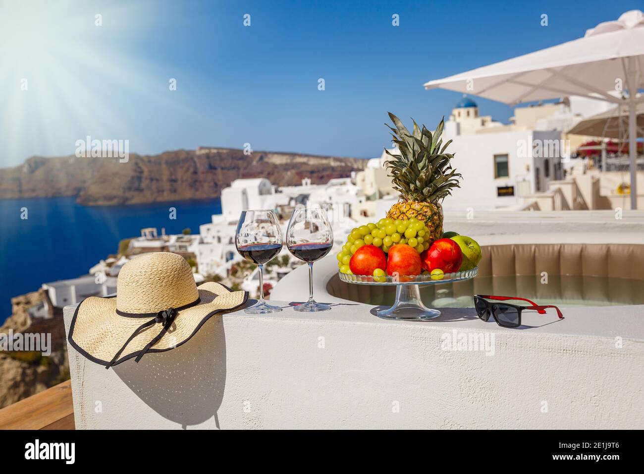 Wein und Obst für zwei Personen auf dem Hintergrund des Meer und die Insel Santorini Stockfoto