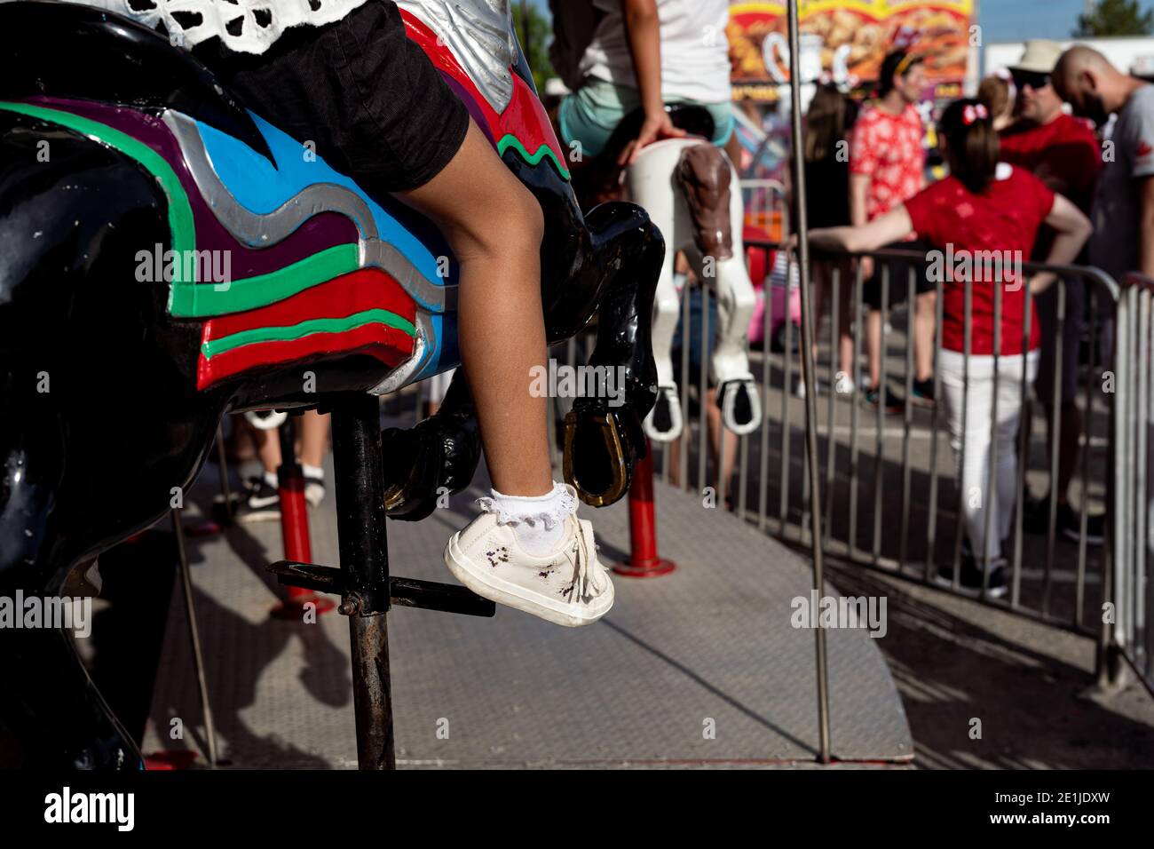Teilansicht von Mädchen Reiten Fahrrad im Sommer auf Bürgersteig, tiefe Schatten Stockfoto