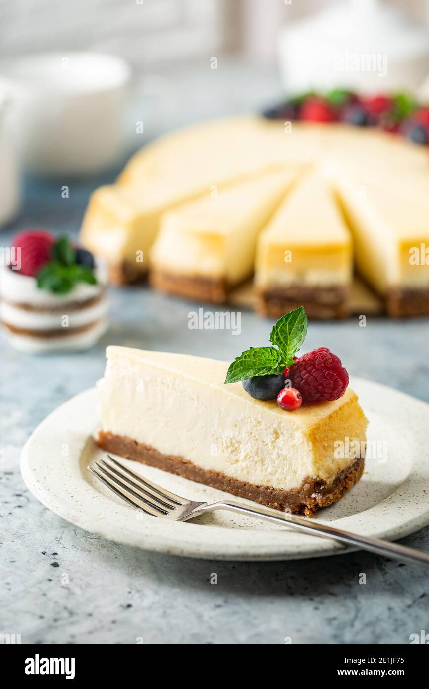 Klassischer New Yorker Käsekuchen mit frischen Beeren auf hellblau Konkreter Hintergrund Stockfoto