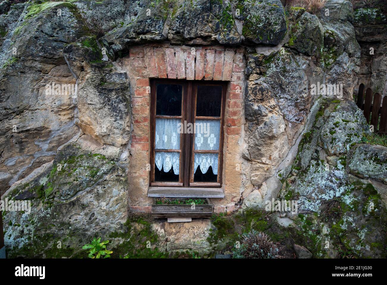 13. Dezember 2020, Sachsen-Anhalt, Langenstein: Das Fenster einer Höhlenwohnung. In Langenstein im Harz warten die Menschen buchstäblich darauf, dass ein hobbit um die Ecke kommt und eine Pfeife raucht. In der Kleinstadt bei Halberstadt gibt es noch ein gutes Dutzend gut erhaltene Höhlenwohnungen, die an das Auenland von den beiden Bestsellern "der Herr der Ringe" und "der Hobbit" des Autors J.R.R. erinnern Tolkien. Die Wohnungen wurden von Bauernfamilien ab 1855 mit Hammer und Meißel in mehrere Sandsteinfelsen gehauen. Heute kümmert sich ein Verein um die Erhaltung der Th Stockfoto