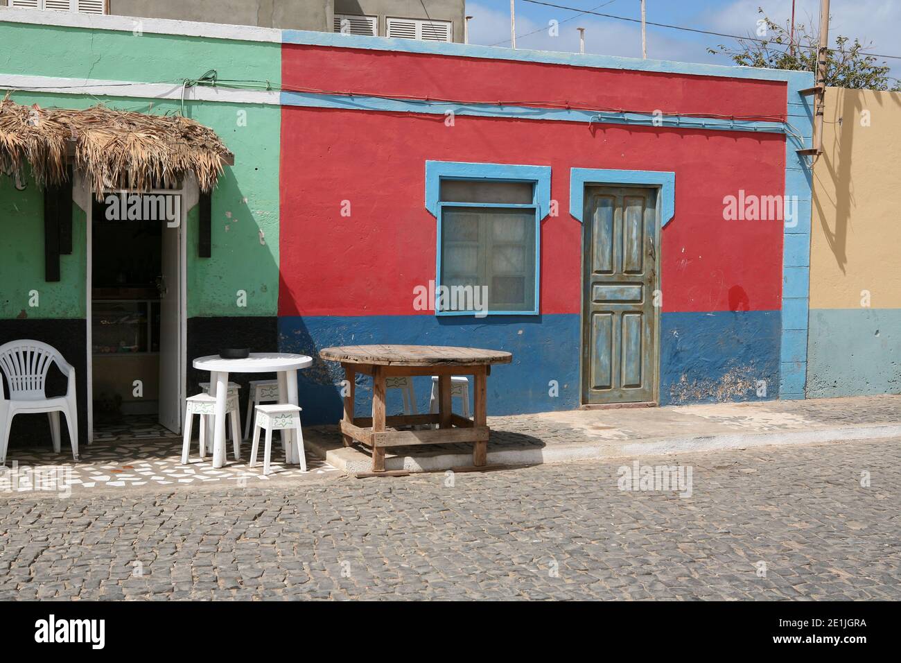 Ruhige Stadt Blick von den Straßen und Gassen von Palmeira. Leere Tische und Stühle vor dem Laden neben dem Eingang. Stockfoto