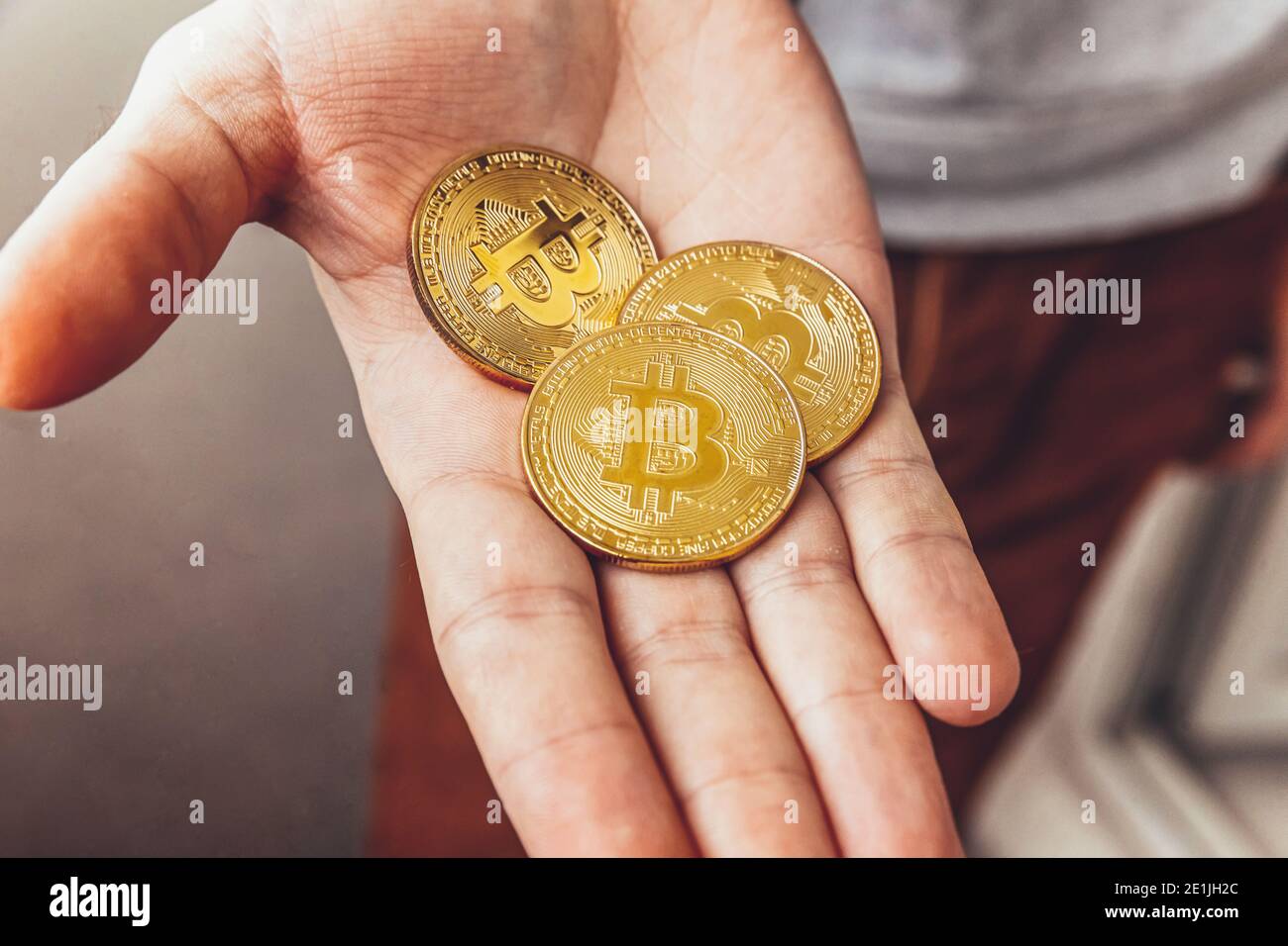 Mann Hand hält Kryptowährung goldene Bitcoin Münze. Elektronisches virtuelles Geld für Webbanking und internationale Netzzahlung. Symbol der Krypto virt Stockfoto