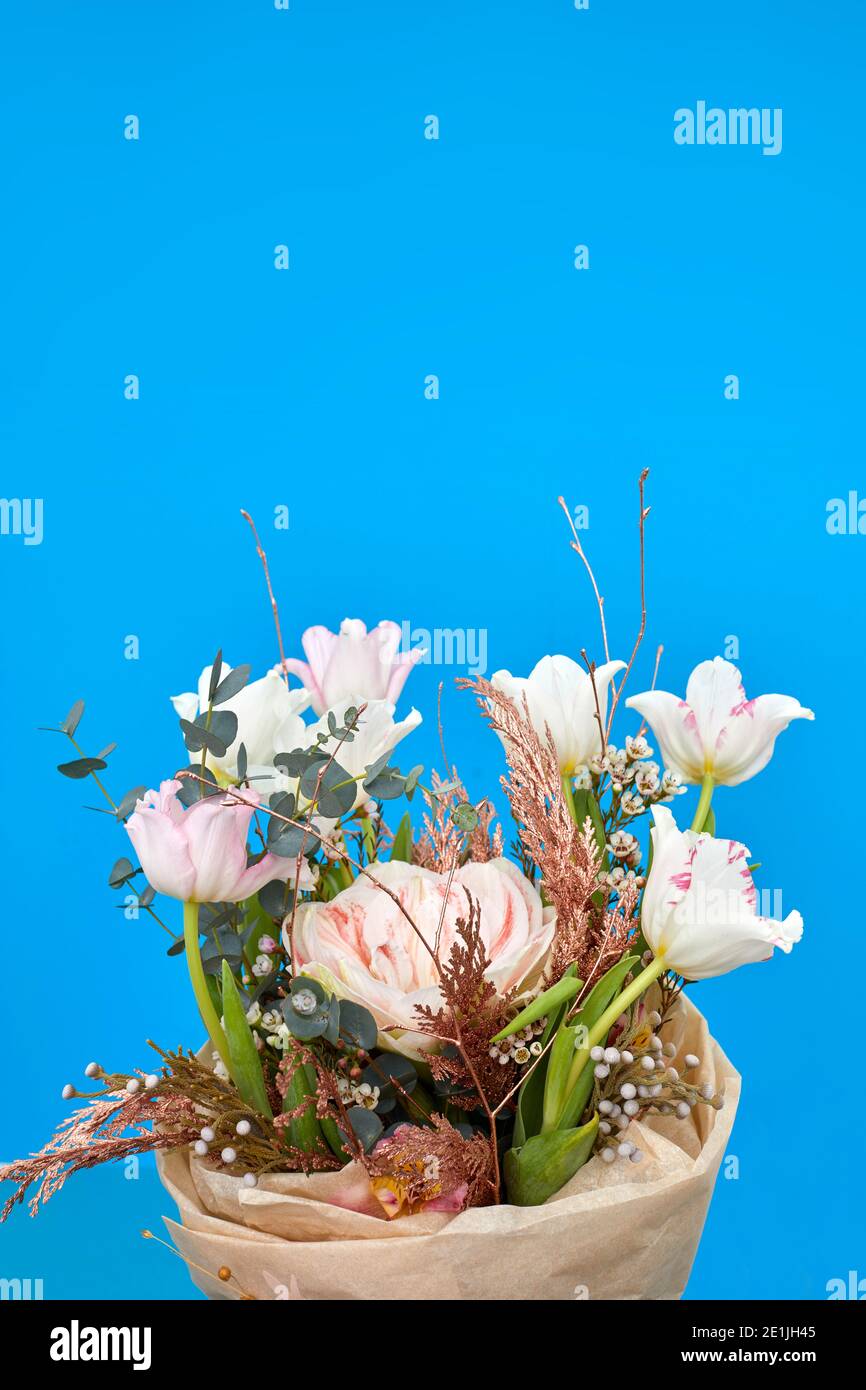 Bouquet von weißen Tulpen und Kräutern auf blauem Hintergrund Stockfoto