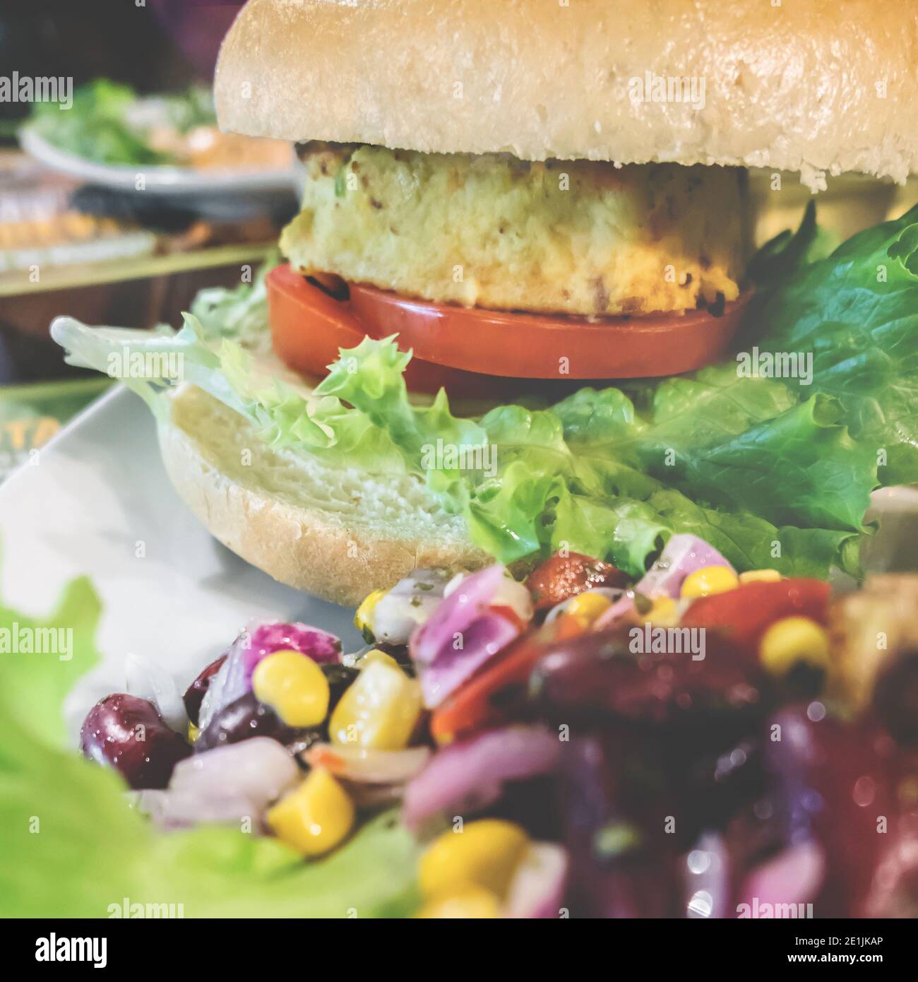 Veganer Hamburger bereit zum Verzehr. Gesundes und vegetarisches Lebenskonzept. Fleischlose Snack auf Basis von Soja mit frischem Gemüse. Flacher Freiheitsgrad Nahaufnahme. Stockfoto