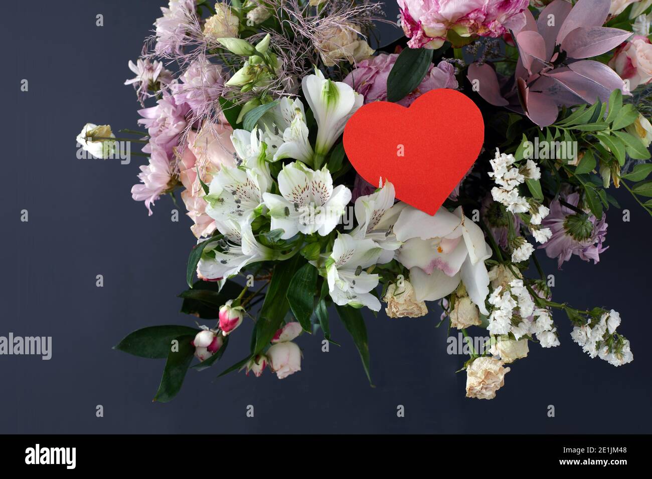 Valentinstag Grußpapier Herz-Karte mit Rose Blumen Blumenstrauß dunklen Hintergrund mit Platz für Ihre Grüße. Draufsicht flach liegend Stockfoto