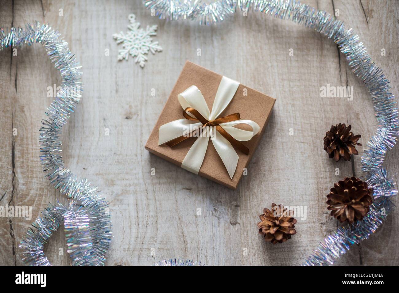 Schöne stilvolle Weihnachten braun Geschenk auf Holzhintergrund. Stockfoto