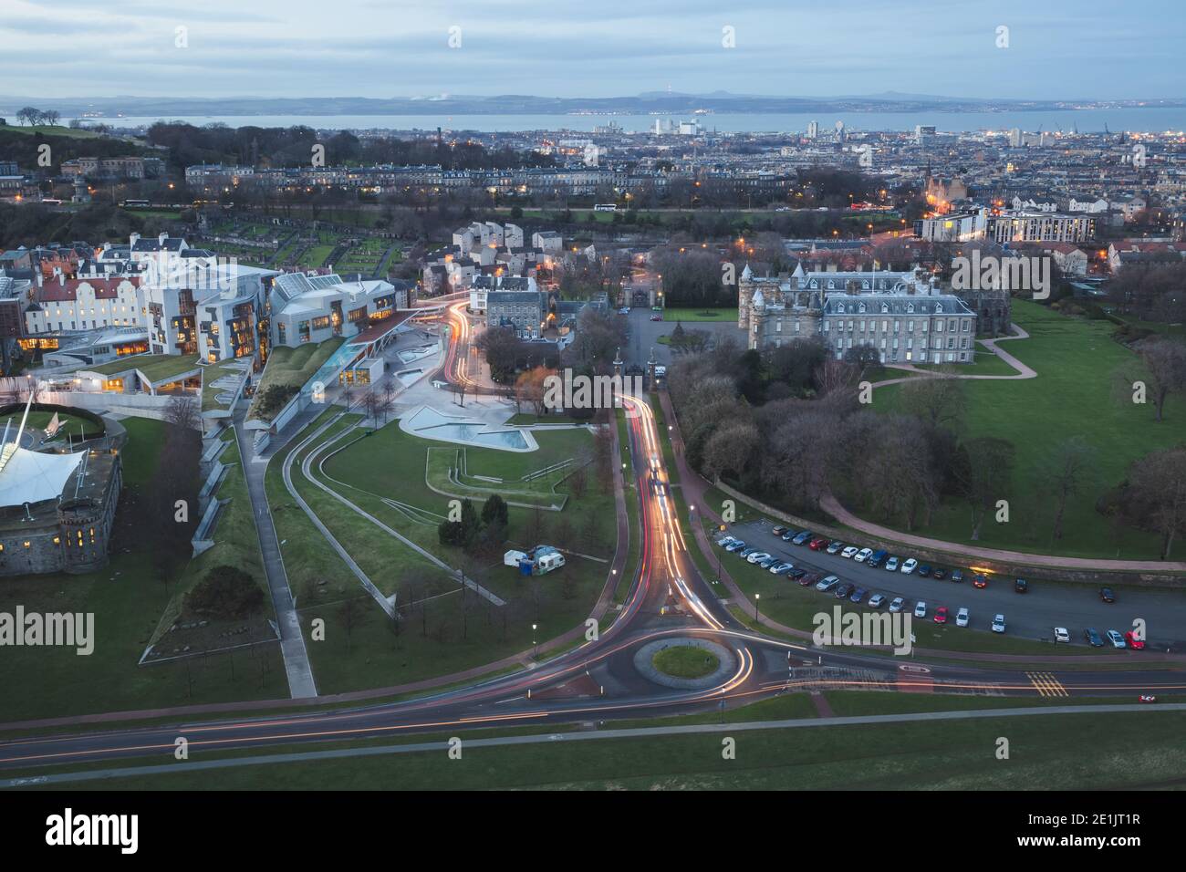 Ein weitläufige Abendblick von Salisbury Crags über die moderne Architektur des Scottish Parliament Building gegenüber dem Holyrood Palace An der Basis Stockfoto