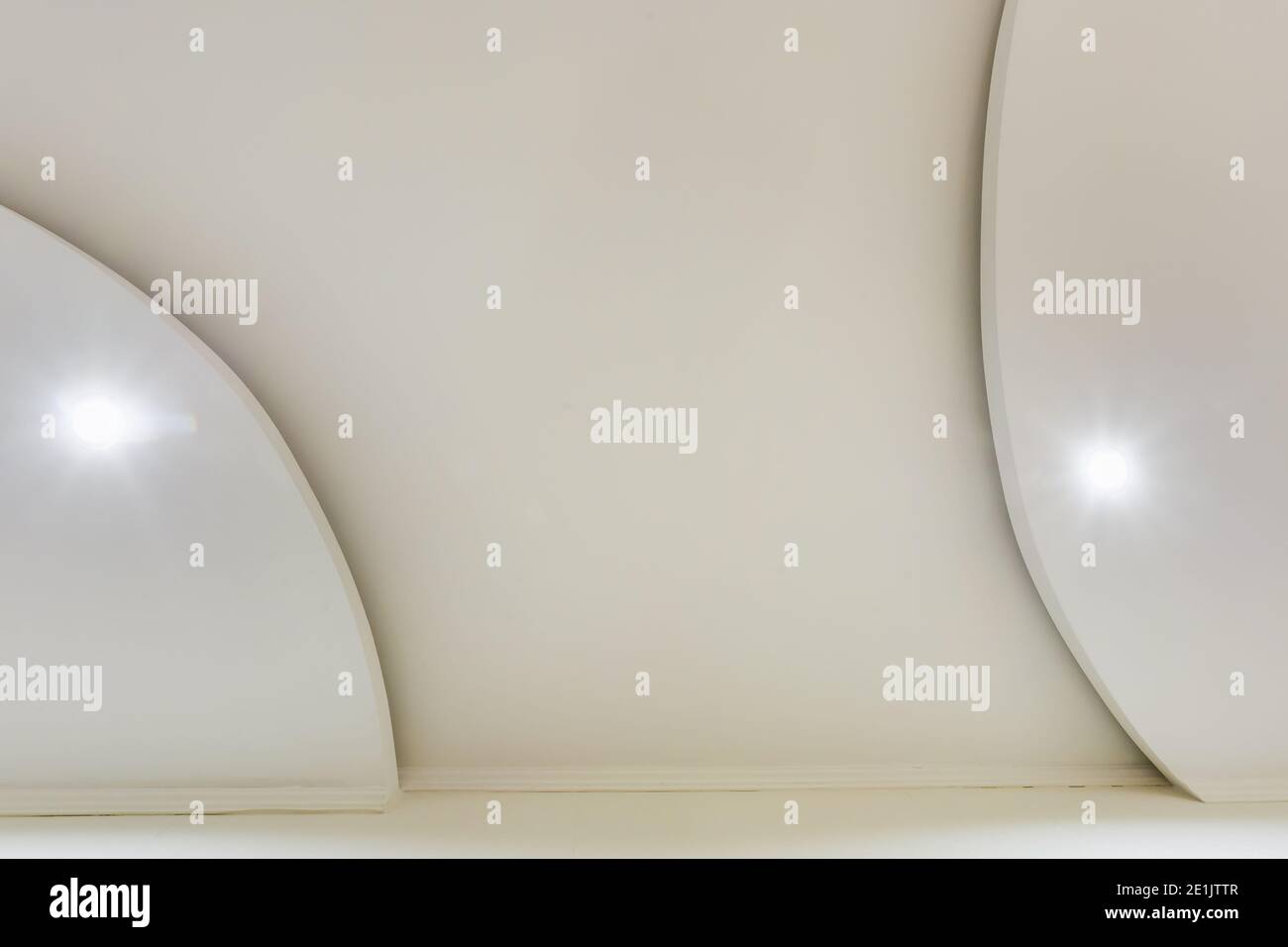 Detail der Eckdecke mit aufwändigen Stuckverzierungen. Abgehängte Decke und Trockenbau in leerem Raum in Wohnung oder Haus. Dehnbare Decke Stockfoto