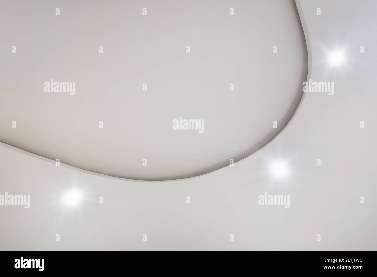 Detail der Eckdecke mit aufwändigen Stuckverzierungen. Abgehängte Decke und Trockenbau in leerem Raum in Wohnung oder Haus. Dehnbare Decke Stockfoto