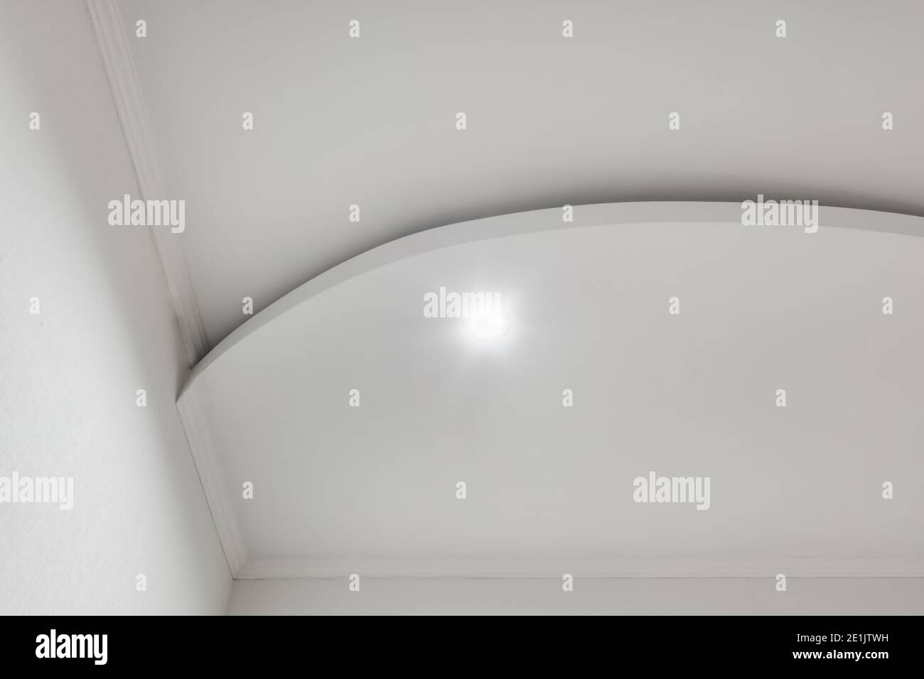 Detail der Eckdecke mit aufwändigen Stuckverzierungen. Abgehängte Decke und Trockenbau in leerem Raum in Wohnung oder Haus. Dehnbare Decke Stockfoto