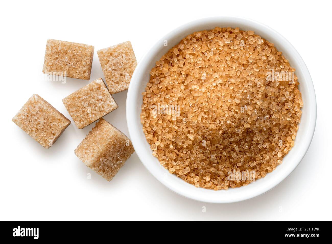 Hellbrauner Granulatzucker in weißer Keramikschale neben hellbraunen Zuckerwürfeln isoliert auf Weiß. Draufsicht. Stockfoto